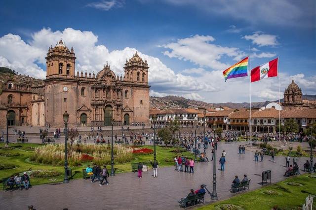 Plaza de Armas de Cusco con la catedral, la bandera del Perú y la bandera del Cusco.