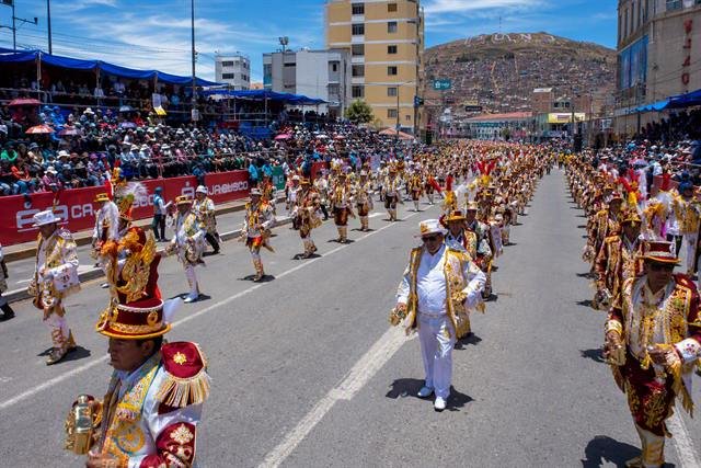Desfile de danzantes con trajes bordados por las calles de Puno ante el público.