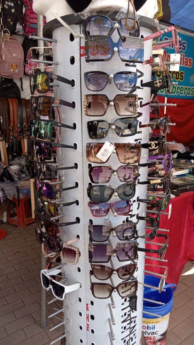 Exhibidor giratorio con decenas de lentes de sol de distintos modelos dentro de la feria.